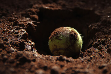 Tennis ball embedded in clay creates crater like impression