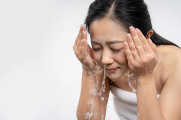 Young woman washing face in room.