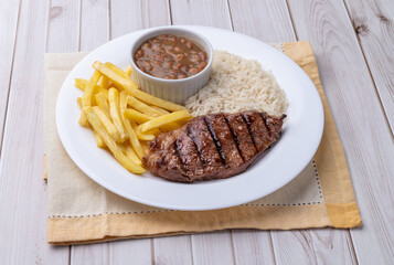 Grilled picanha beef, rice, beans and french fries. Typical brazilian executive dish
