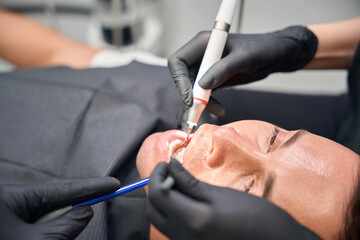 Aesthetic dentistry client lying on the dentist chair with open mouth