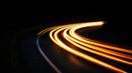Long exposure captures illuminated curves of winding road at night showing movement and light trails