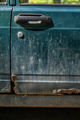Damaged vintage rusted car texture with peeling paint and corroded metal