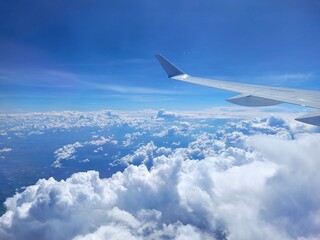Blue Sky with Clouds and Airplane Wing
