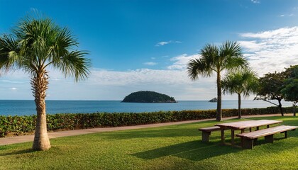 peaceful ocean view from a landscaped park with palm trees benches and a distant forested island