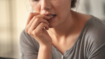 Nervous young woman biting her nails