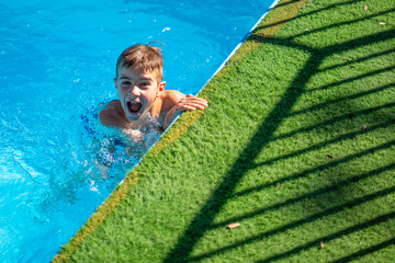 Child enjoying summer holidays in a swimming pool with copy space