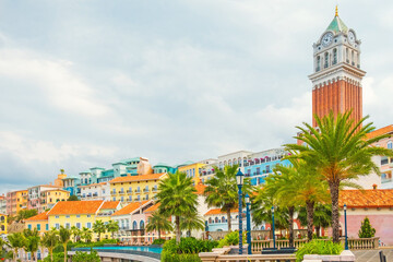 Colorful Mediterranean style buildings with palm trees and tall clock tower in Sunset Town, Phu...