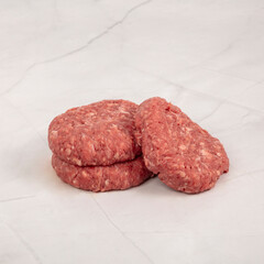 Fresh raw burger patties stacked on a clean marble surface for cooking – High Resolution Raw Meat Image for Food Industry or Food Packaging