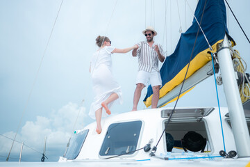 A young couple are enjoying seaside adventure aboard a yacht