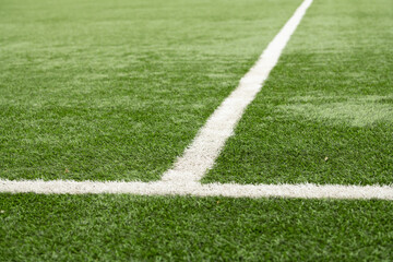 Obraz premium A well-maintained soccer field displays bright green grass, marked by white lines defining the boundaries and center circle, showcasing a perfect setting for a football match