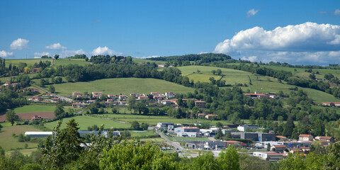 Panorama sur un village et une zone industrielle ou commerciale des Monts du Lyonnais