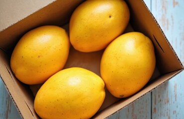 Fresh ripe yellow mango fruits in a corrugated box on a wooden background. Close-up shot of tropical mangoes. Healthy food, fresh farm harvest. Organic raw produce. Delicious vegetarian meal.