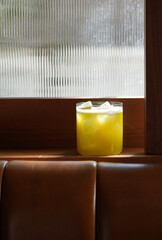 Vibrant yellow cocktail served in a rocks glass filled with ice
