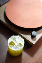 Vibrant yellow cocktail served in a rocks glass filled with ice