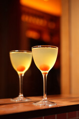 Classic cocktail glass with cherry in a nightclub bar counter, close-up