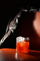 Classic orange cocktail with ice cubes served in a rocks glass nightclub restaurant, close-up