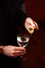 Elegant Hand Holding a Modern Cocktail with Caviar Garnish..