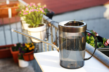 watering can for balcony flowers. growing flowers on the terrace