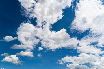 Nice puffy clouds against a blue sky as a background in graphics.