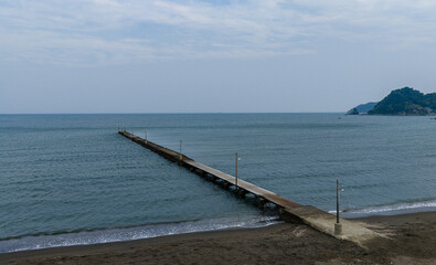 Fototapeta premium Haraoka Pier Extending into the Calm Sea under a Cloudy Sky, Chiba, Japan