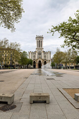 Saint Etienne in France, city center, Cathedrale Saint Charles with forecourt and fountain surrounded by shops and cafes in spring © A.Freund