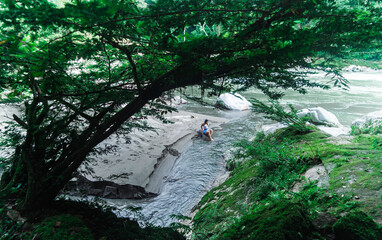 Beautiful girl bathing in a waterfall in the jungle