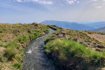 Water stream flowing from melting snow in the spring, Sierra Nevada range, Andalusia, Spain