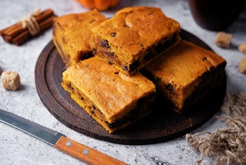 Pumpkin cake with chocolate filling in a plate on a wood cutboard on a grey background
