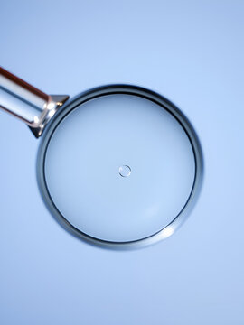 Delicate close-up of a hydroscopic magnifying glass revealing intricate details of a tiny droplet of water on a
