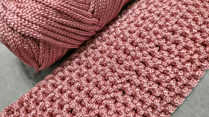 Knitting elements of a pink women's bag, hand knitting with a long handle.