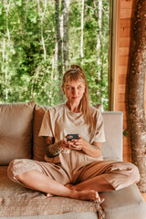 Woman Using Mobile Phone in Log Cabin