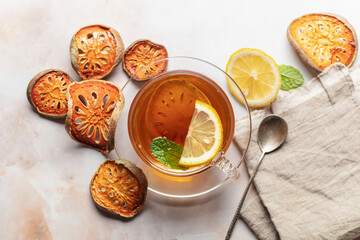 Thai healing matoom tea made of dried bael fruit slices with lemon and mint in transparent glass...