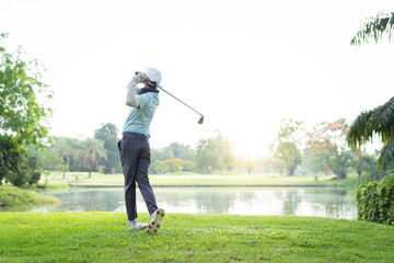 Asian amateur golfer is performing a tee off swing, man playing golf in golf course.