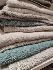 Close-up of Folded Fluffy Towels in Blue Gray and Beige Hues with Soft Texture