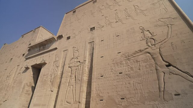 View of inscriptions on the Pylon of the Temple of Horus on a sunny day, Edfu, Egypt, North Africa, Africa
