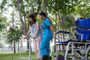 Elderly female patient sits in wheelchair waiting area, talks with caring doctors and nurses, discusses treatment, recovery and medical support with compassion.