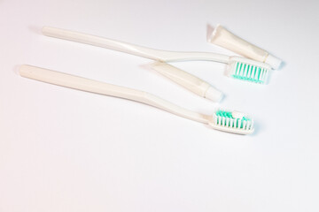 A minimalist dental kit featuring two toothbrushes and toothpaste, with a clean, white design, conveying a sense of hygiene and simplicity.