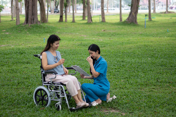 Elderly female patient sits in wheelchair waiting area, talks with caring doctors and nurses, discusses treatment, recovery and medical support with compassion.