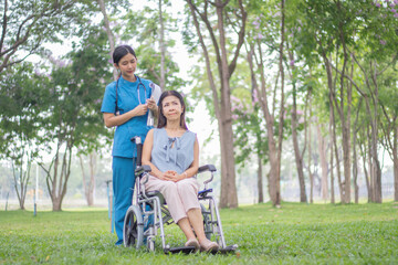 Elderly female patient sits in wheelchair waiting area, talks with caring doctors and nurses, discusses treatment, recovery and medical support with compassion.