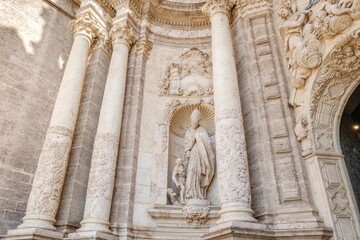 Ornate entrance of the cathedral of Valencia, showing its intricate stone carvings and historic architecture. Intricate Facade Detail Of Valencia Cathedral, Historic Baroque Architecture