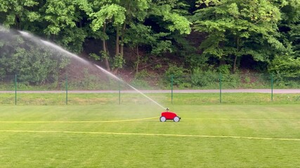Automatic sprinkler watering green sports field lawn