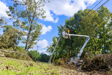 Utility worker uses cherry picker to repairs on power lines entangled in power lines under
