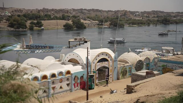 View of colourful Nubian village overlooking Nile river on a sunny day, Nagaa Suhayl Gharb, Aswan, Egypt, North Africa, Africa