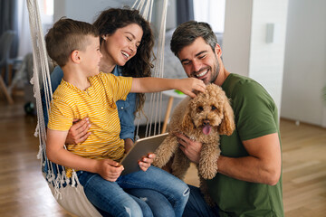 Parents and child relaxing at home with computer watching funny internet video, making online call