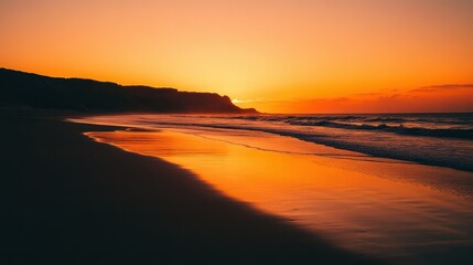 Fototapeta premium Fiery sunset at the beach. Waves coming ashore. Calm, peaceful view.