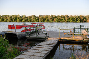 Boat at a wooden pier with a forest in the background
