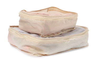 Beige packing cubes with folded clothes isolated on white