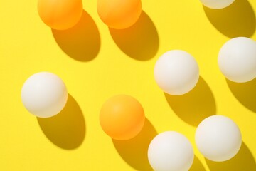 Ping pong balls on yellow background, flat lay