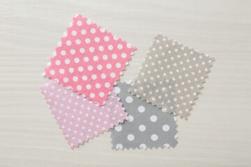 Obraz premium Samples of different fabrics on white wooden table, flat lay