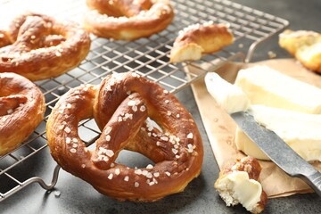 Tasty pretzels with salt and butter on grey table, closeup